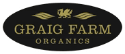 Logo for Graig Farm Organics featuring a gold Welsh-style dragon and leaf motifs on a black oval background, with gold text reading “GRAIG FARM ORGANICS.”