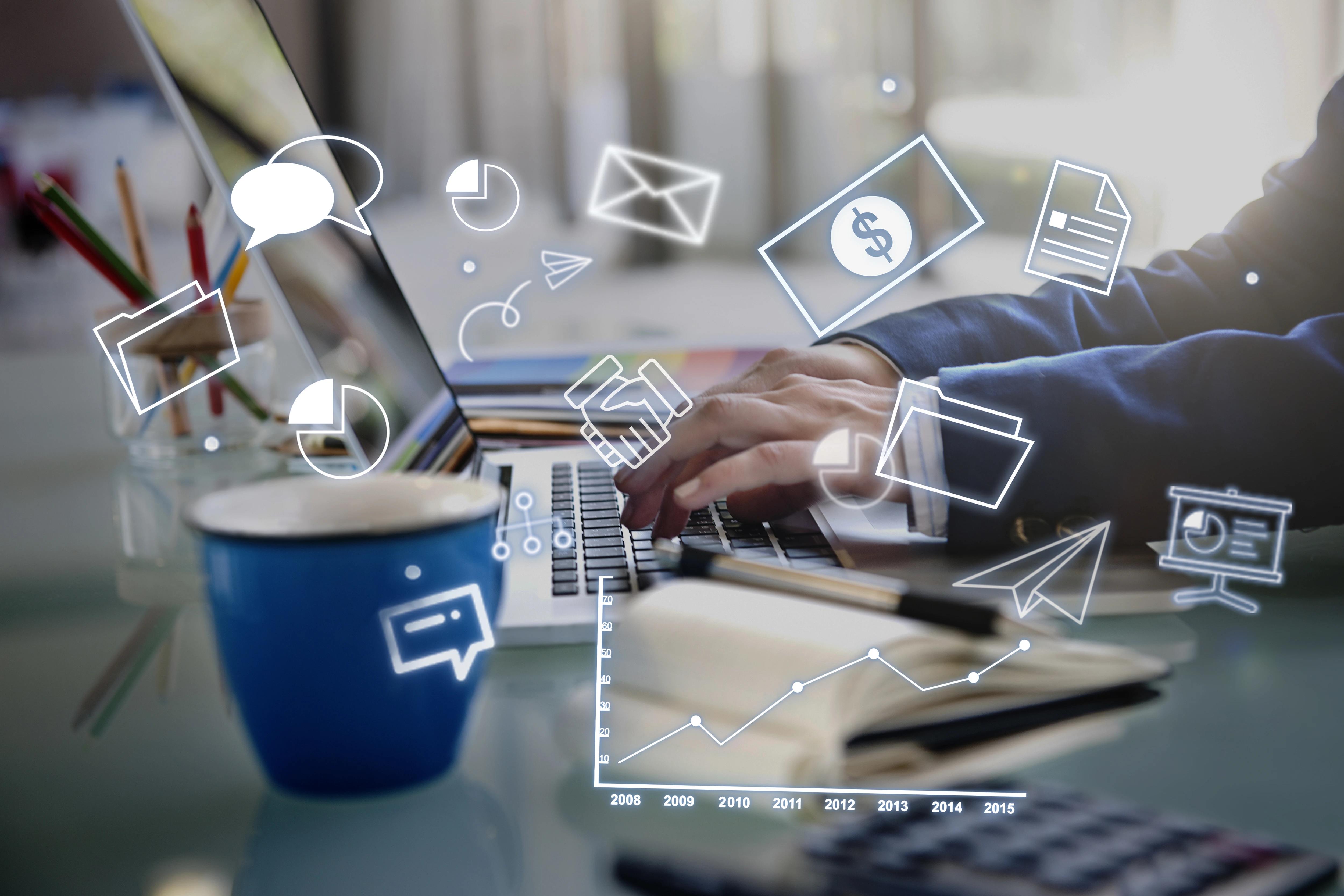 Person typing on a laptop at a desk with digital icons representing business and communication, illustrating data-driven work at a content marketing agency.